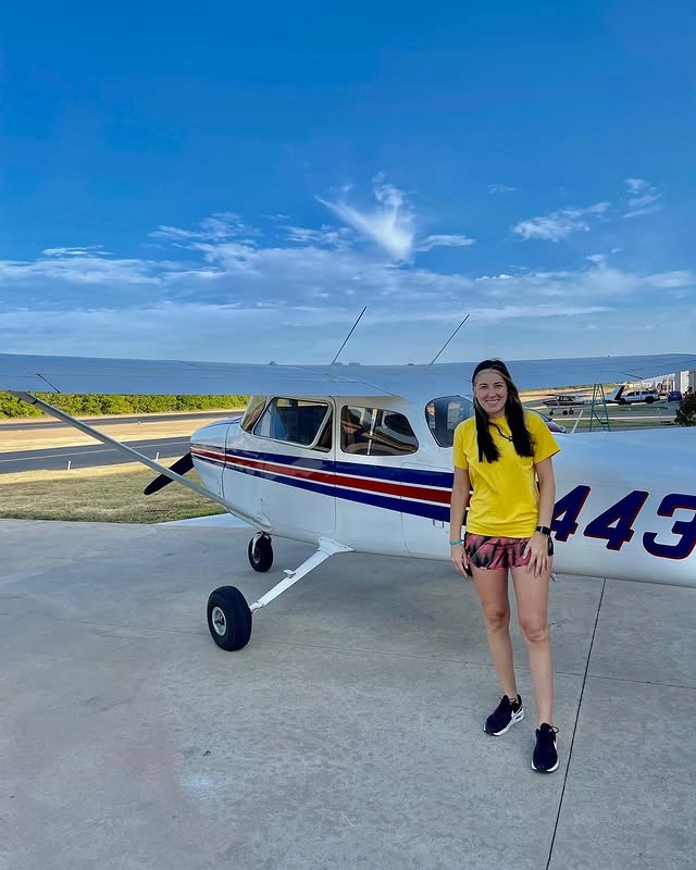 Instructor with student next to aircraft holding a tshirt piece after student completed a flight