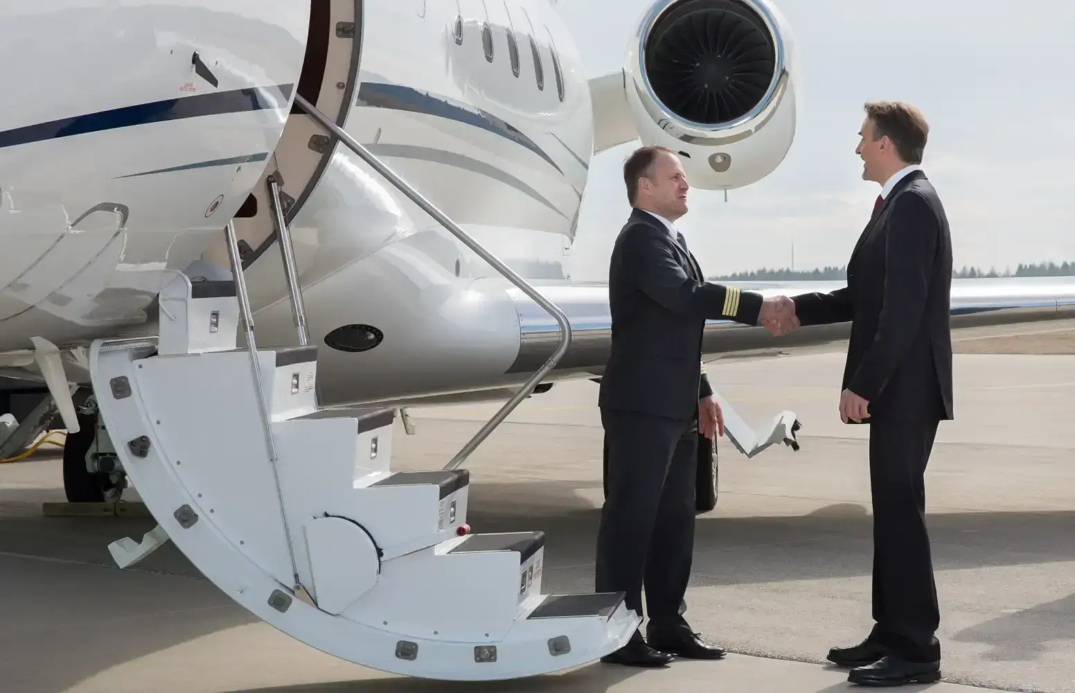 Corporate pilots standing next to a private jet